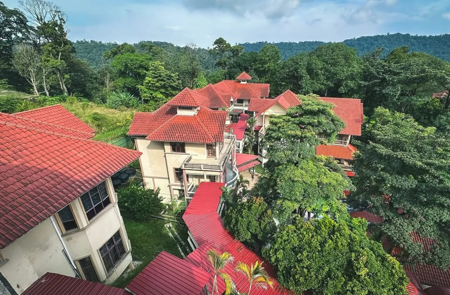 Aerial view of Samara Tualang School's red-roofed bungalows surrounded by forest in Sungai Penchala, Kuala Lumpur