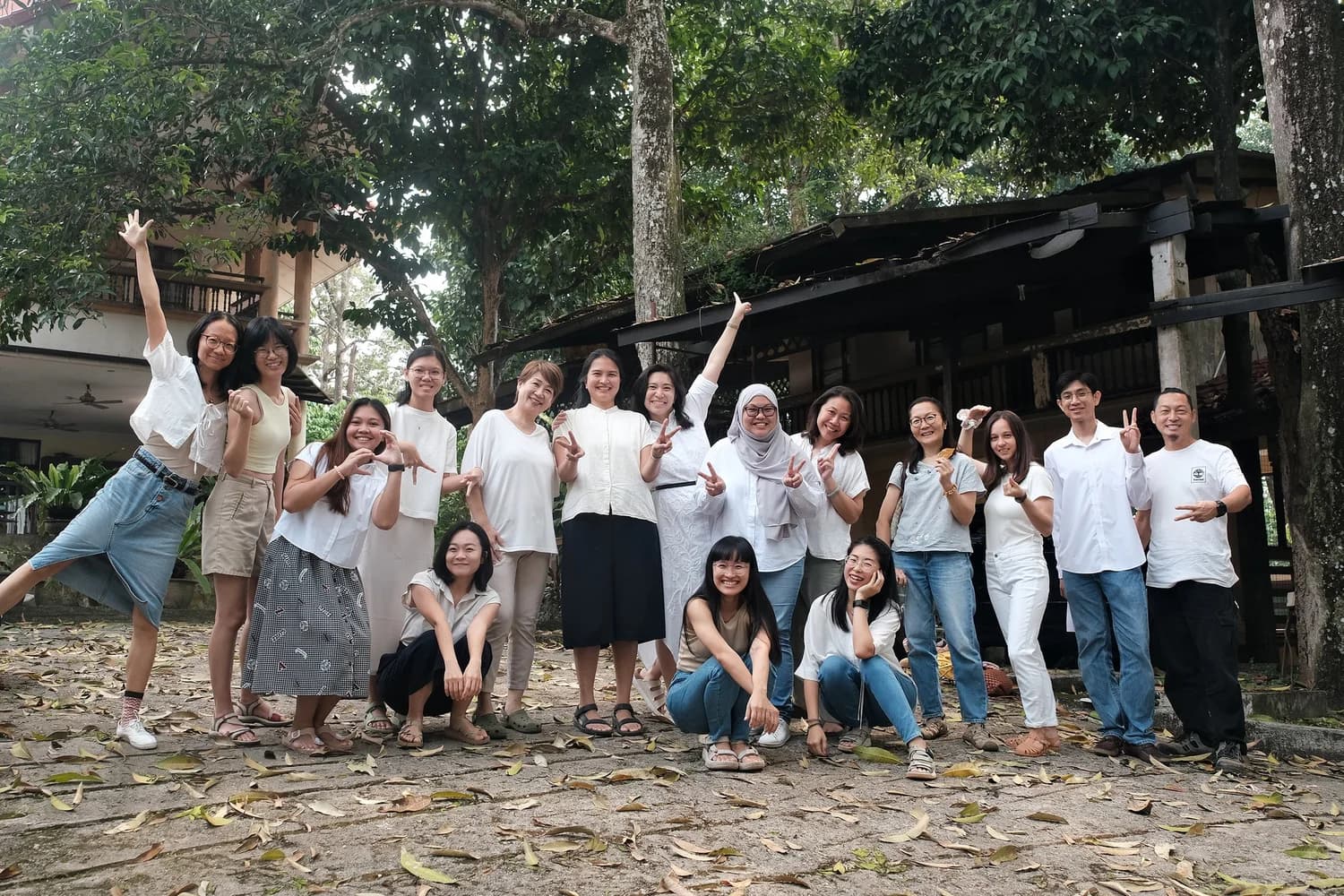 Samara Tualang School teachers and staff together in the tree-shaded courtyard of the Sungai Penchala campus
